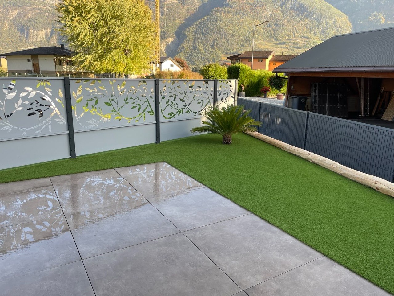 Terrasse avec gazon synthétique et clôture décorative